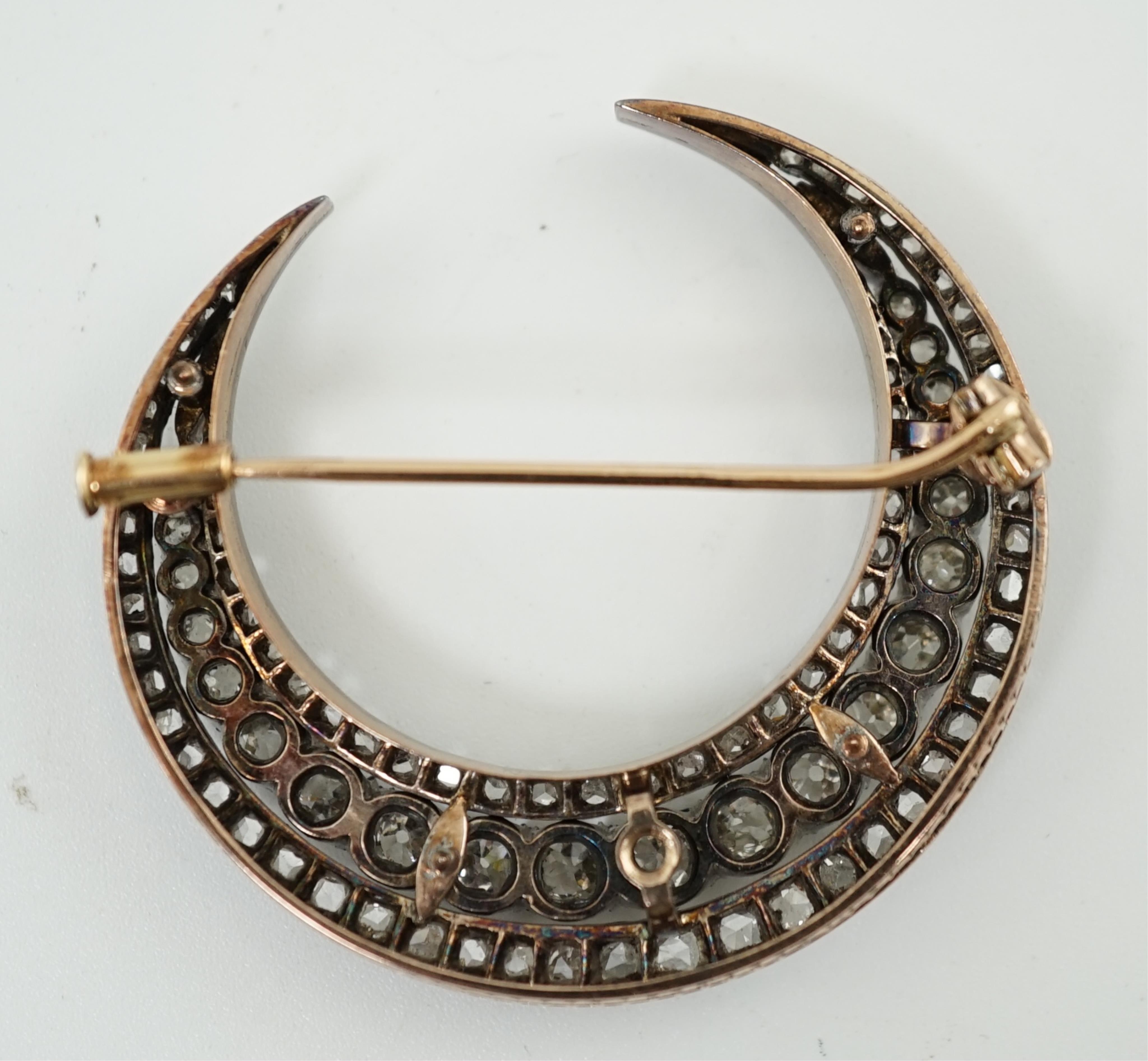 A late 19th/early 20th century French 18ct gold and silver, old mine and rose cut diamond set three row crescent brooch